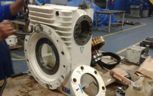 Máquina industrial desmontada em oficina com peças e ferramentas, ilustrando vibração e desalinhamento em equipamentos — contexto técnico da Femes Ferramentaria.